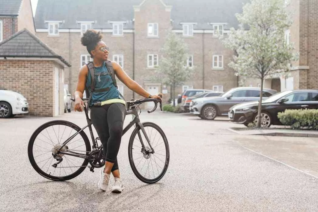 Improving Fitness To Cycle To Work - Elle leaning on her bike and looking to the right 