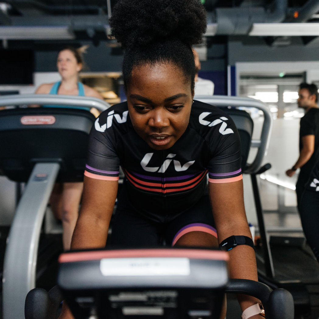 Close up of Elle on indoor cycling bike during workout in Liv cycling jersey 